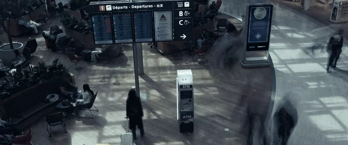 A busy airport terminal with people and departure boards