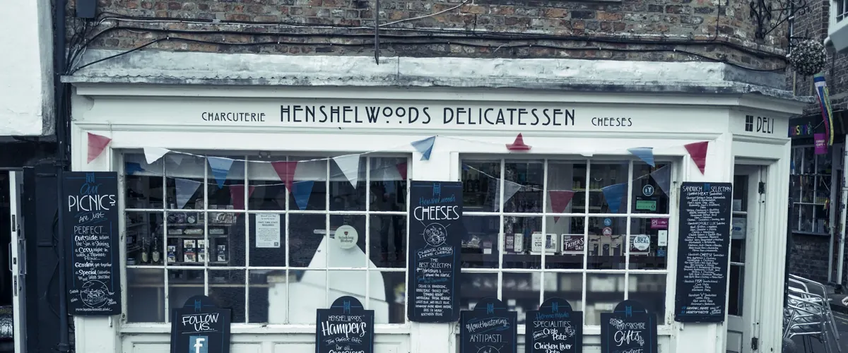 An independent delicatessen shopfront with bunting and chalkboard signs