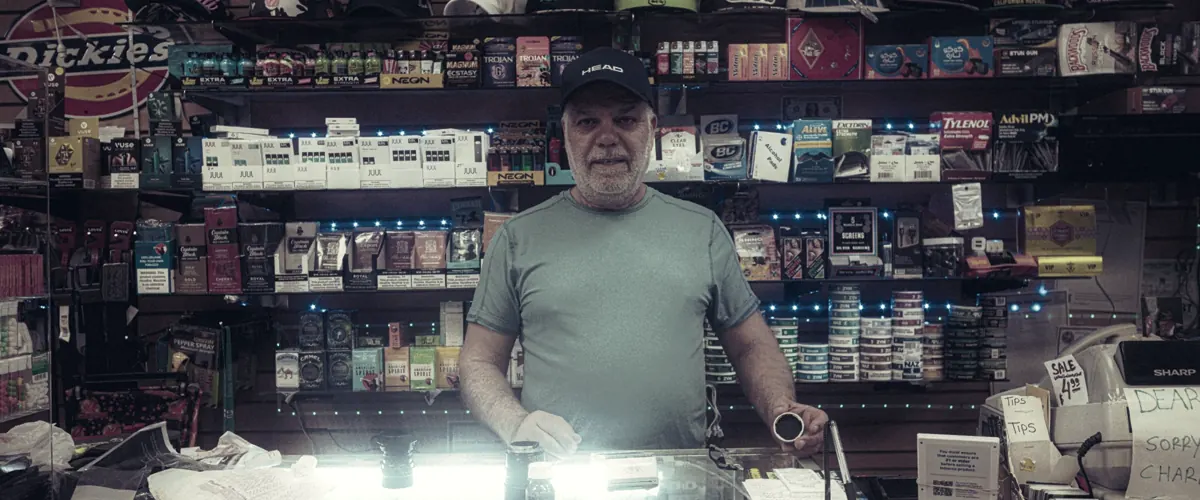A man standing behind a counter in a store